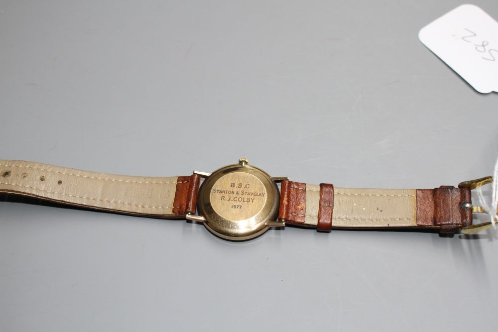 A gentlemans 9ct gold Bulova Longchamp manual wind wrist watch, on associated strap.